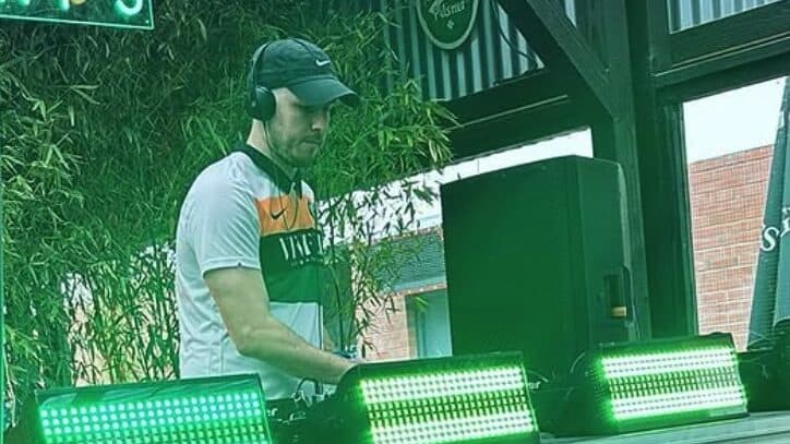 High-energy DJ performing at Lavery's bar, with vibrant green LED lighting creating an engaging atmosphere. Perfect for nightlife entertainment and live music events in Belfast.