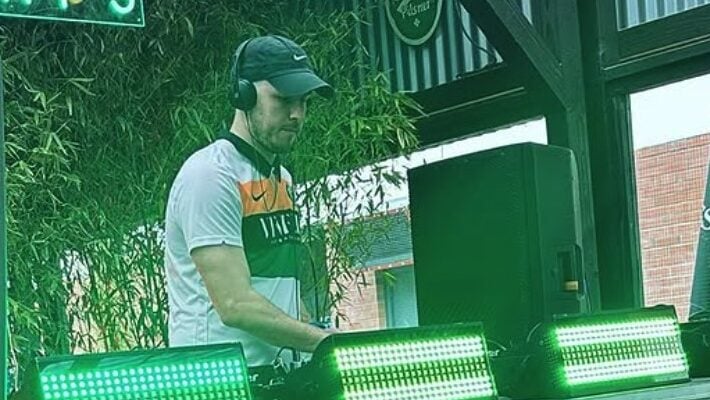 High-energy DJ performing at Lavery's bar, with vibrant green LED lighting creating an engaging atmosphere. Perfect for nightlife entertainment and live music events in Belfast.