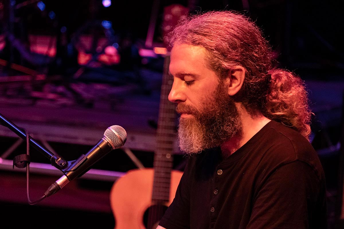 Donal Scullion performing live at Lavery's with a microphone and guitar in the background, capturing a moment of musical performance.