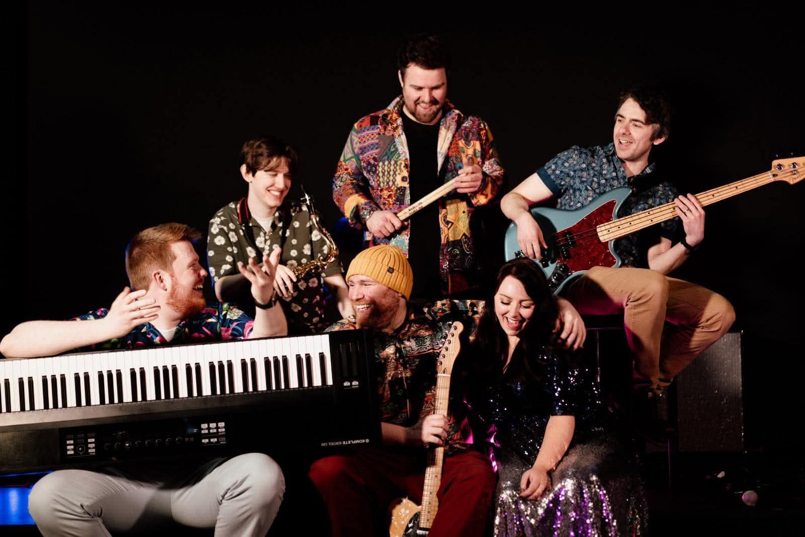 Group of musicians performing live at Lavery's, featuring guitar, keyboard, and vocals, during a vibrant concert event.